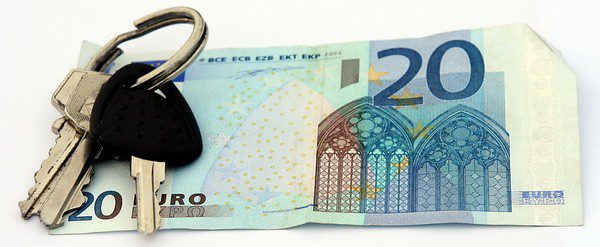 A picture of car keys on top of a 20 Euro bill